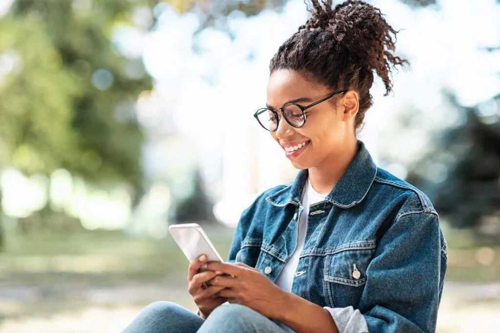 black lady with smartphone using mobile app sittin Z96AR67 1024x683 1